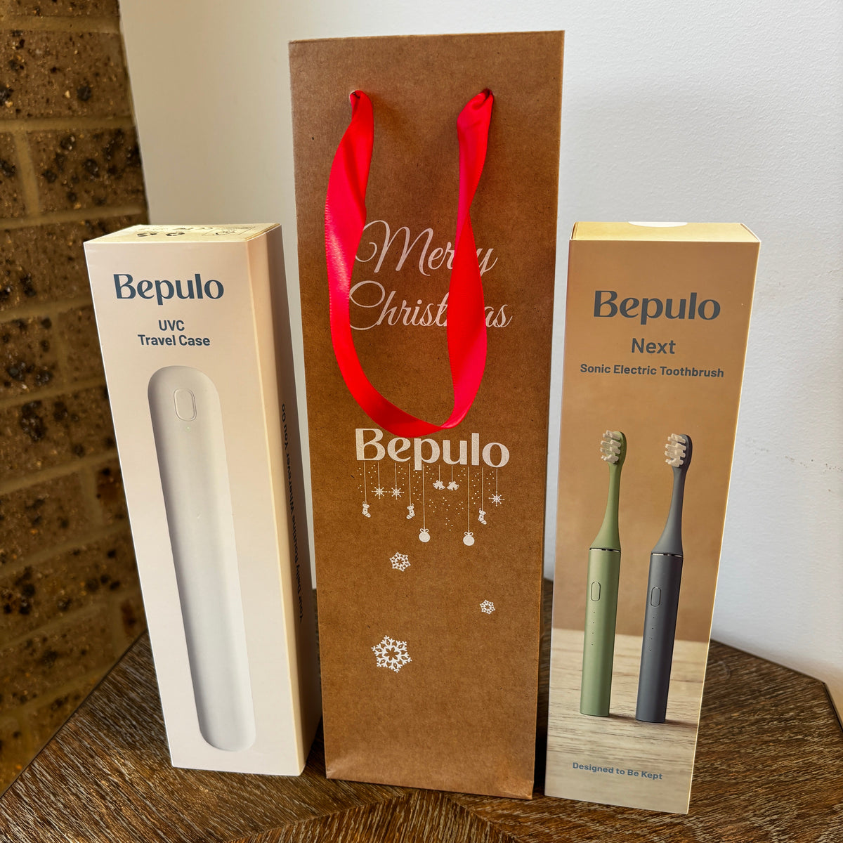 Gift bag standing upright between 2 Bepulo toothbrush packages