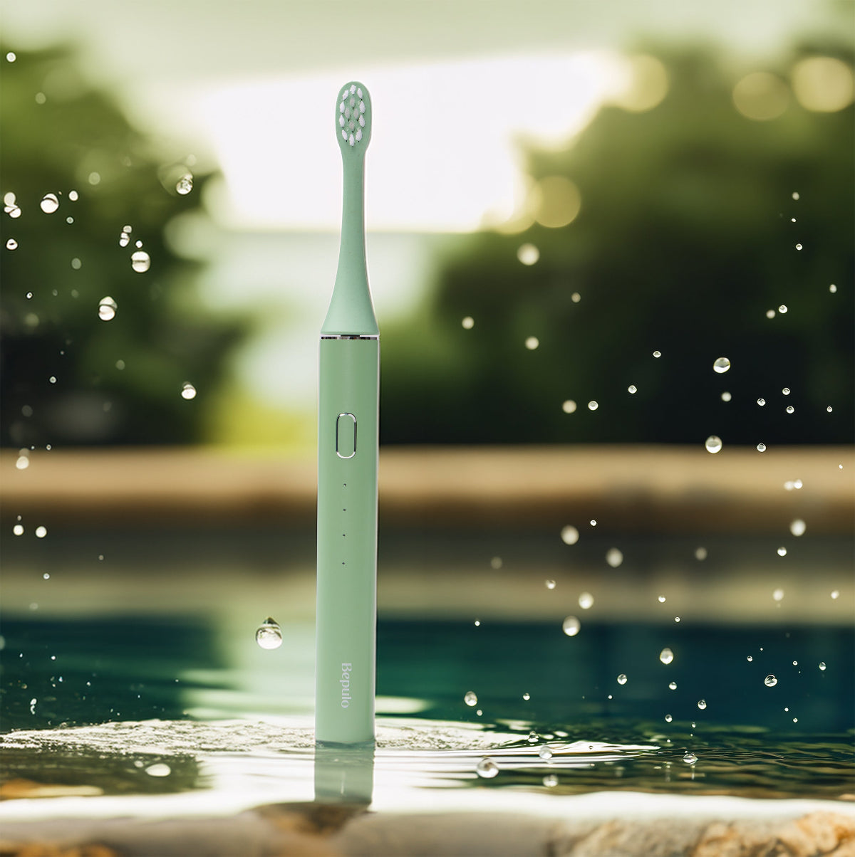 Pistachio Green Bepulo Next sonic electric toothbrush standing by an outdoor pool with splashing water droplets. #colour_pistachio green