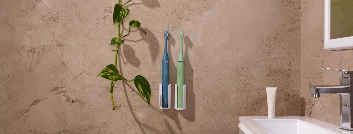 2 Bepulo electric toothbrushes mounted on a travertine stone tile in a luxurious bathroom