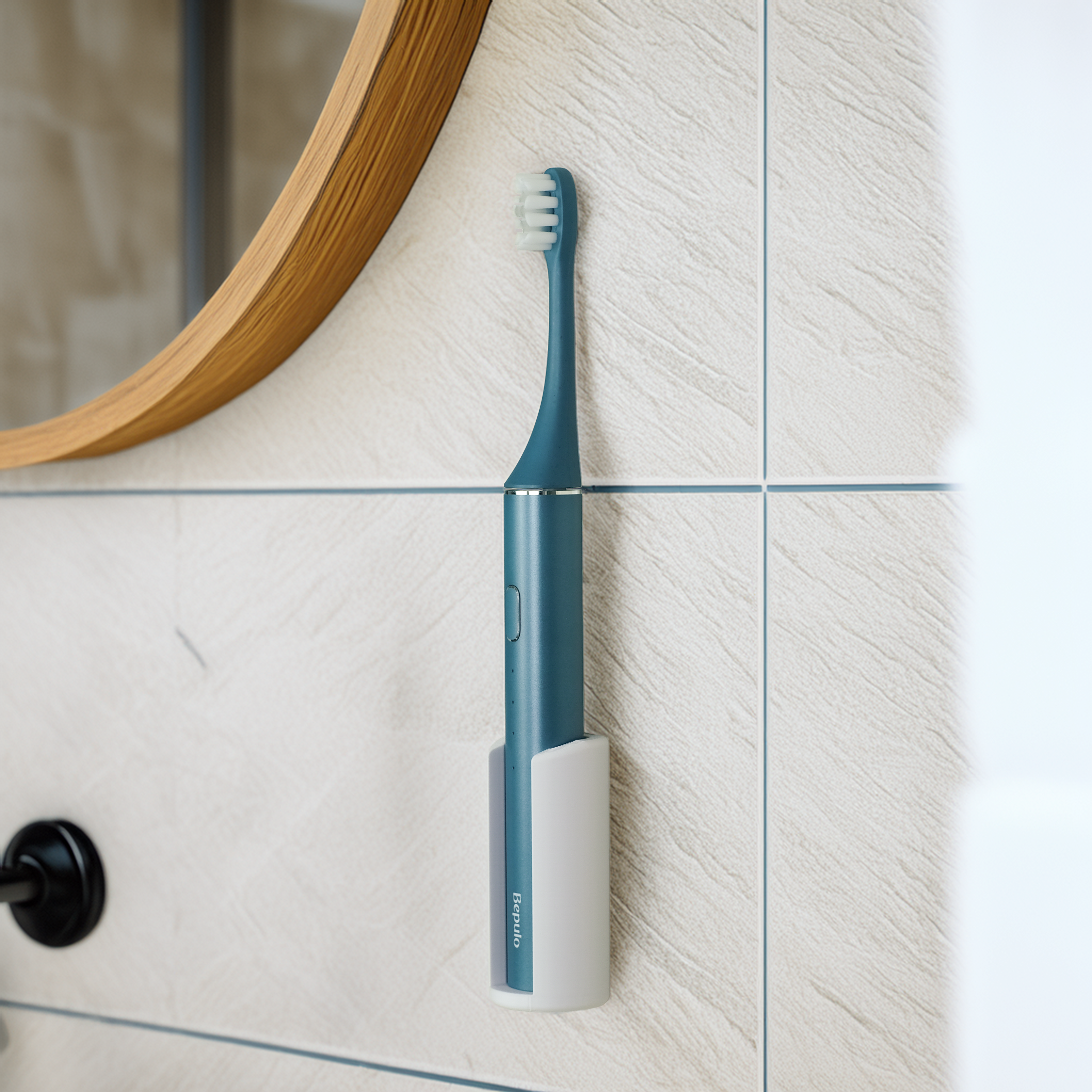 A Bepulo electric toothbrush with white bristles is mounted on a light beige tiled bathroom wall in a white holder, with part of a round wooden mirror visible in the upper left.