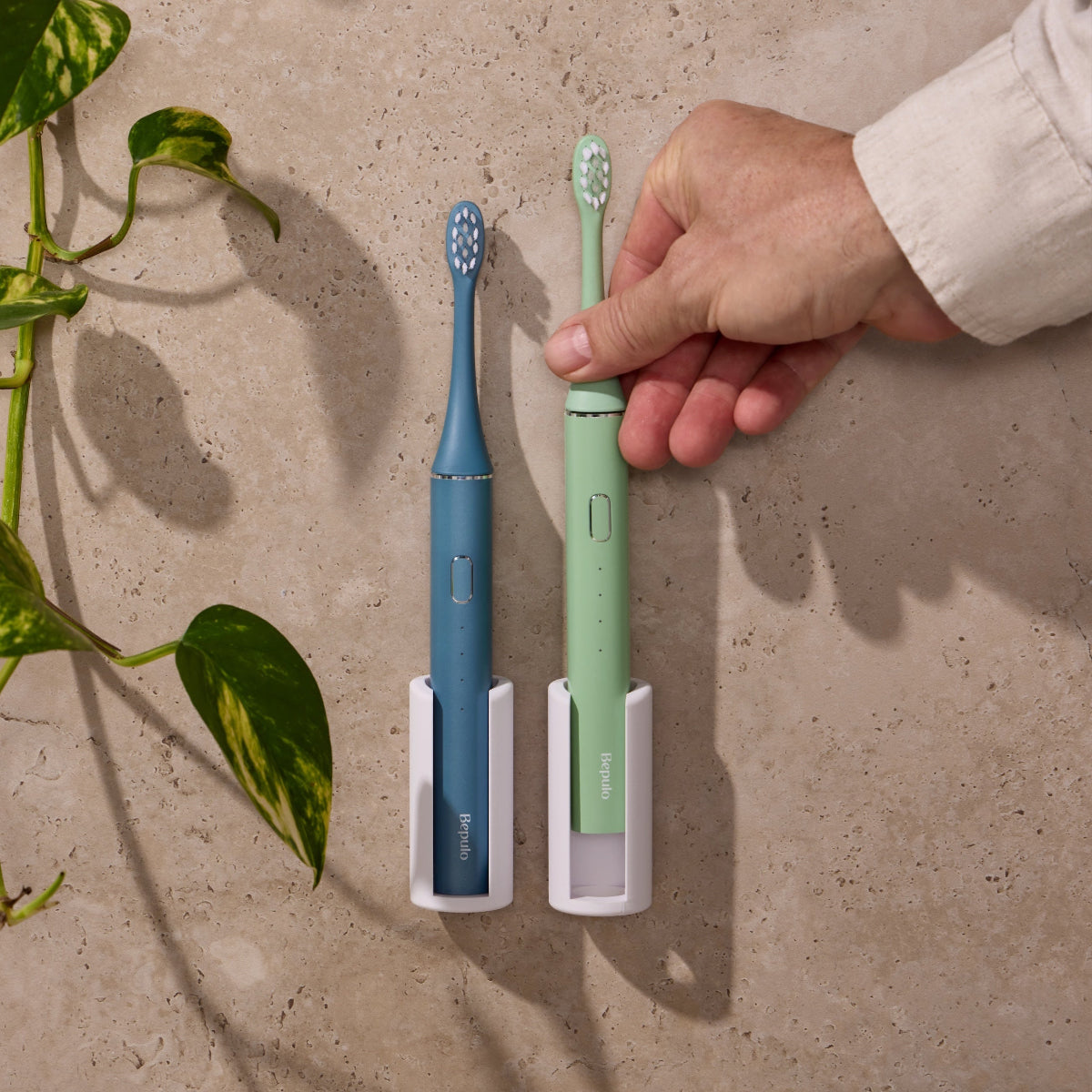 Two Bepulo Next sonic electric toothbrushes mounted on white Bepulo Wall Holders. #colour_pistachio green