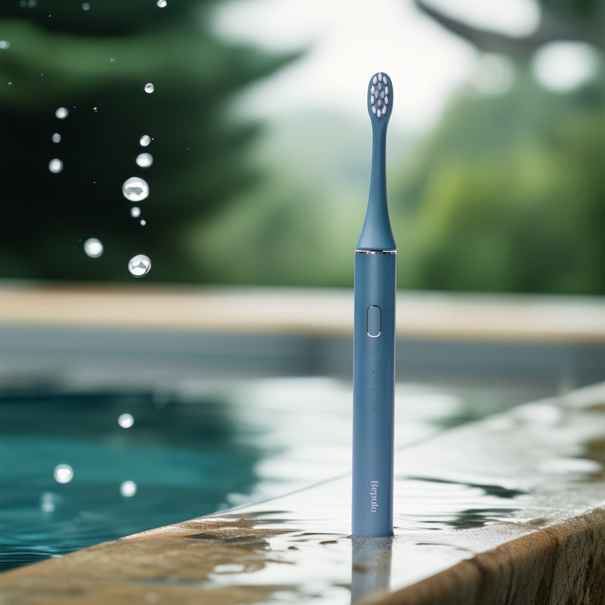 Sapphire Blue Bepulo Next sonic electric toothbrush standing on a stone ledge by a pool. #colour_sapphire blue