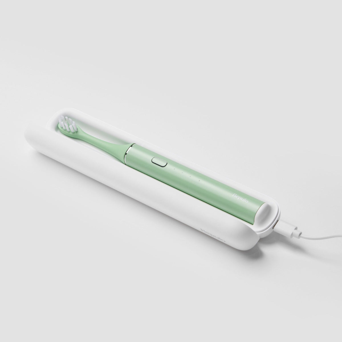 Bepulo Next pistachio green sonic electric toothbrush charging inside its white travel case. #colour_pistachio green